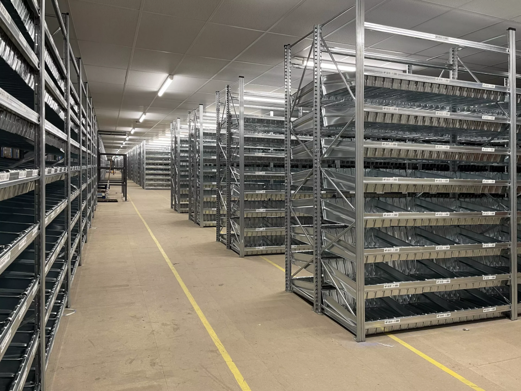 Large warehouse storage area with multiple rows of galvanised Unirack shelving and clear floor access aisles.